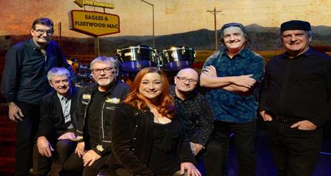 Image shows The Illegals bandmates with drum set and Eagles and Fleetwood Mac sign in background.