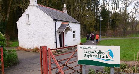 Image shows entrance to the Lagan Valley Regional Park with a white cottage in the background