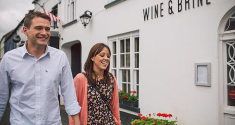 Couple walking outside the Wine & Brine restaurant