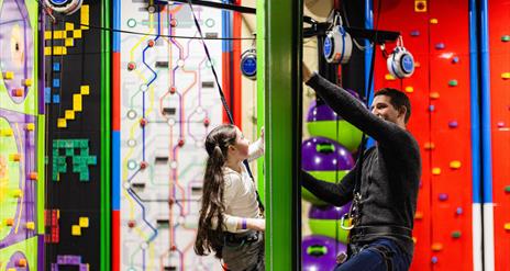 Young Girl and Dad on Face to Face Climbing Wall