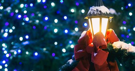 Christmas lights with a lantern wrapped in a red ribbon