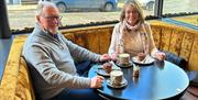 Image is of customer's enjoying coffee and cake in Arthur's Coffee House