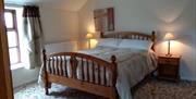 Image is of double bedroom with bedside tables and lamps