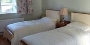Image is of twin bedroom with wooden floor