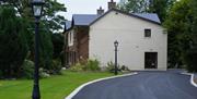 Shows image of side view of property and drive way with lawn