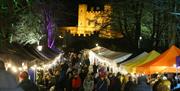 The dark walk full of people going to the market with the Fort lit up in the background
