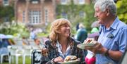 Male and female eating a burger in front of Hillsborough Castle