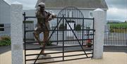 Sculpture of Harry Ferguson looking over his gate