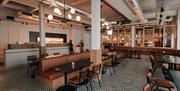 Image shows large restaurant area with lots of tables and chairs and designer flooring