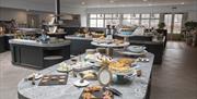 Image shows a creative display of food showing a selection of deserts on a grey marble worktop