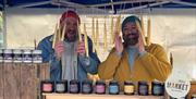 Two stall holders holding candles
