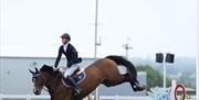 Image is of rider and horse show jumping