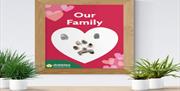 Image is of a wooden frame with a title Our Family with some pawprints
