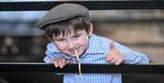 Young boy leaning over fence