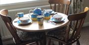 An image of a round dinning table with three chairs