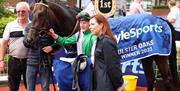 Picture of jockey with owner and horse