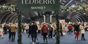 Tedberry Market sign with visitors and traders