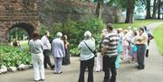 Image is of people on a guided tour of Castle Gardens