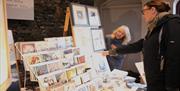 Trader showing customer art prints.