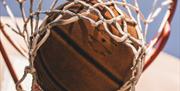 An image of a basketball falling through a net