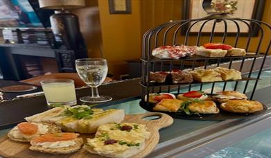 Image of afternoon tea, sandwiches, scones and drinks.