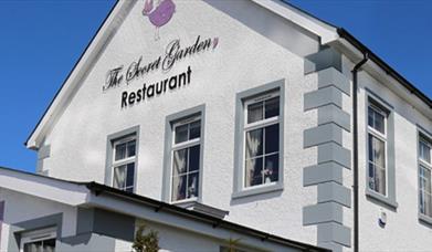 Image shows the outside of The Secret Gardens Restaurant.
