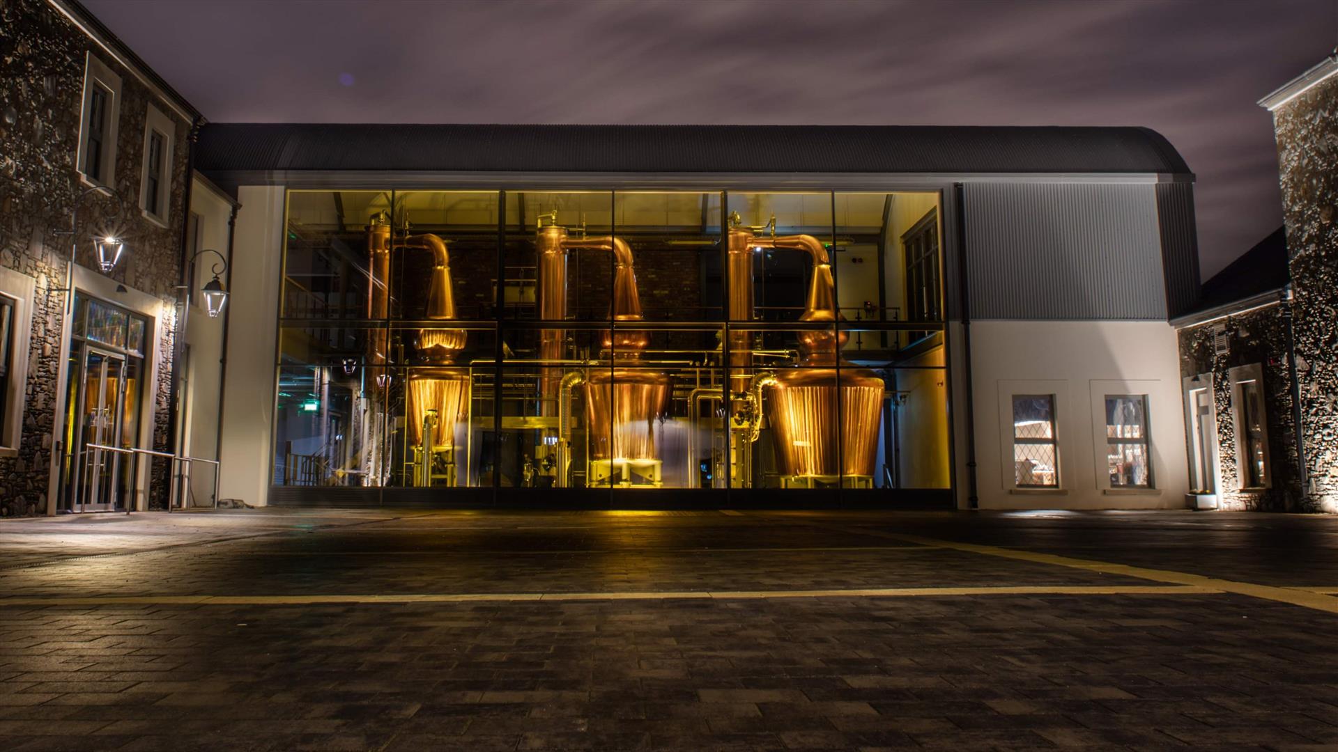 View of the distillery at night across the courtyard
