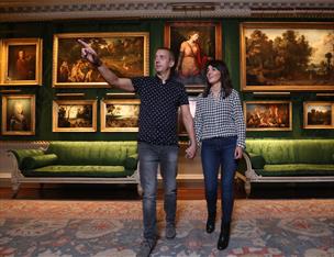 A couple looking at the art in The Throne Room inside Hillsborough Castle