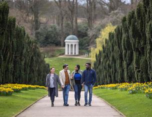 Group of four people walking through Hllsborough castle Gardens