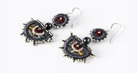 Image shows a pair of dangly, colourful earrings