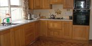 Image shows kitchen with tiled floor and all mod cons