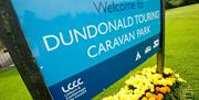 Image shows signage for the caravan park and a welcome sign
