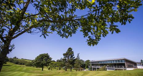 Image shows main building with golf course and trees