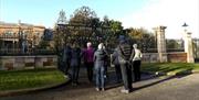 Image shows members of a walking group standing at the  gates of Hillsborough Castle