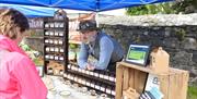 Image shows a stall holder chatting to a customer at his stall selling jams and chutney