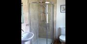 Image shows bathroom with shower, sink and toilet