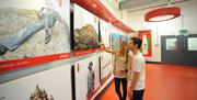 Image shows a man and a woman viewing exhibition images