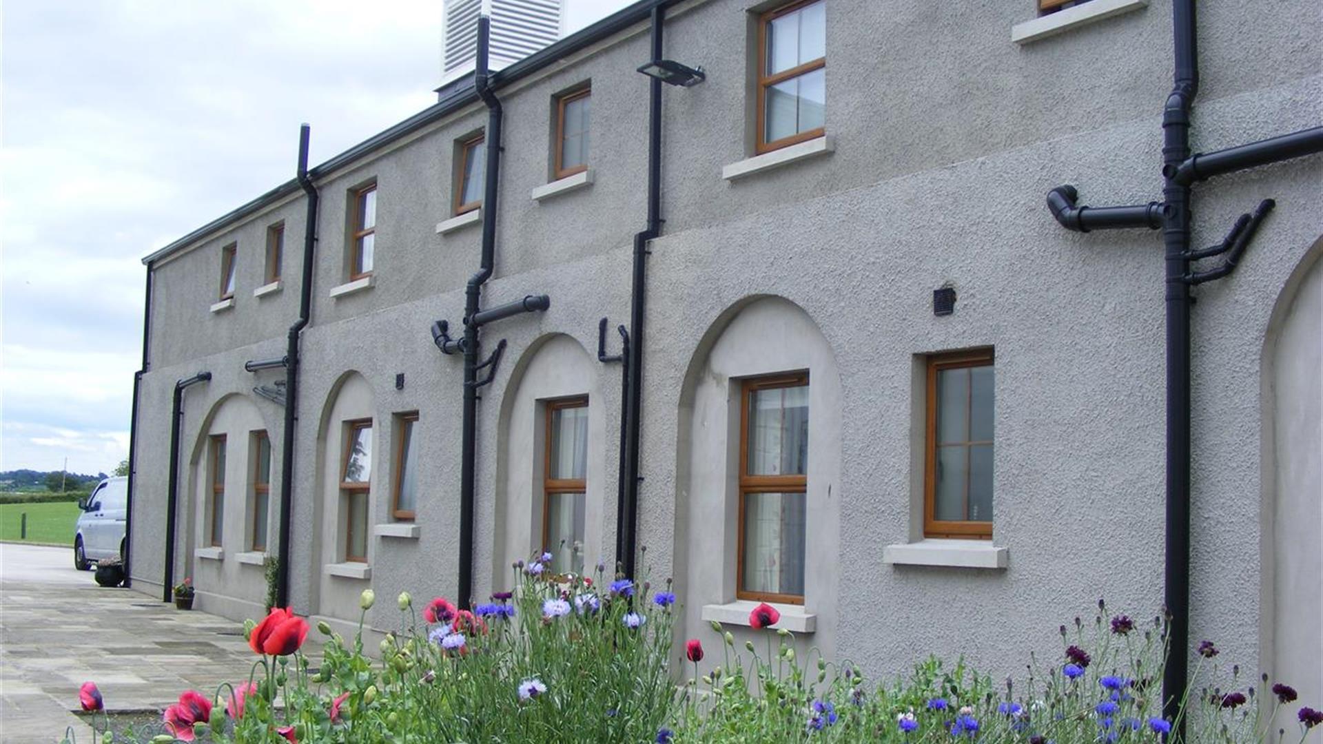 Image is of front of property with flower beds