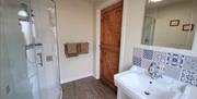 En-suite shower room with shower, sink and toilet.