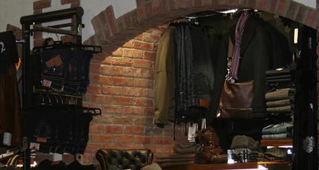 Image shows men's clothes for sale inside shop