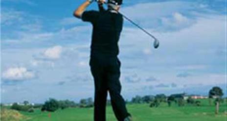 Image is of a male golfer swinging his golf club