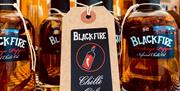 Image is of Blackfire Chili Oil bottle on a checked tablecloth