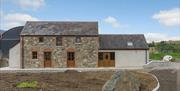 Image shows front of stone built property plus extension