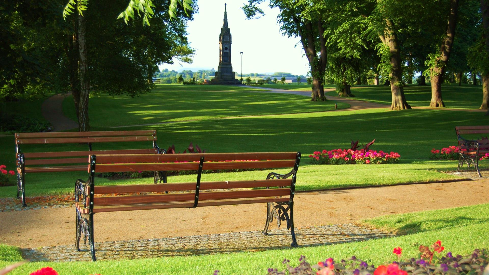 Image is of 2 park benches in the grounds of Castle Gardens in Lisburn
