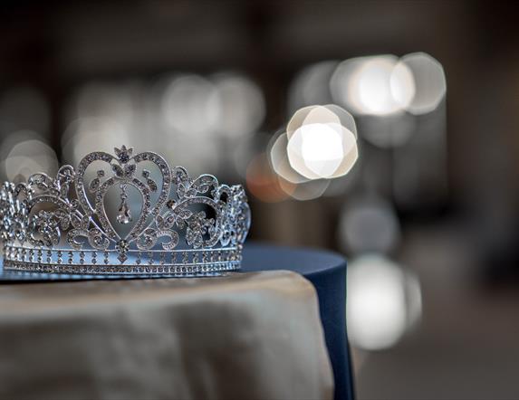 A crown on a table with lights behind it