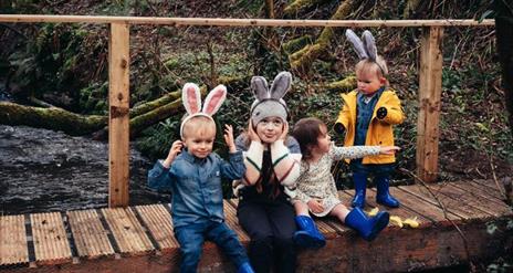 4 children sitting on a wall dressed in Easter costumes