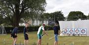 Image is of males taking part in archery