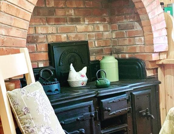 Image shows Aga in kitchen area with explosed brickwork surrounding it