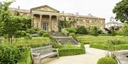 Image is of the rear of Hillsborough Castle showing steps down to a bench