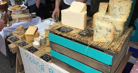 Image shows a stall of various cheeses at the Inns Cross Market